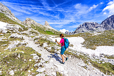 Woman hiking on mountain path in summer, Sesto Dolomites, South Tyrol, Italy