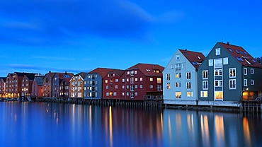 Evening light reflects on buildings along the water during blue hour in Trondheim, creating a calm scene in the heart of the city