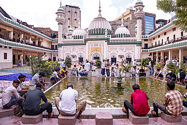 Worshipers perform ablutions in the water basin in the courtyard of the Jama Masjid Khairuddin Grand Mosque in Amritsar, Punjab, India,