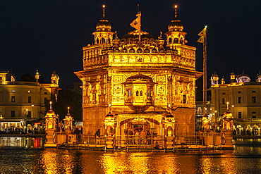 The Golden Temple, a sacred Sikh site in Amritsar, India, sparkles brilliantly at night. Darwar Sahib (shrine) and Amrit Samovar (basin)