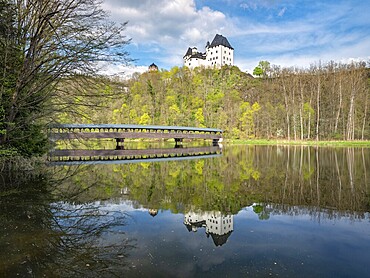Burgk Castle and the covered wooden footbridge are reflected in the river Saale in spring, Burgk, Thuringia, Germany
