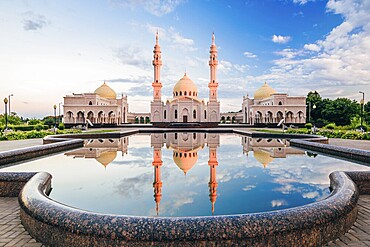 Beautiful White Mosque with Domes and Minarets at Sunset Light. Reflection on Water Surface. Bolghar, Rusiia