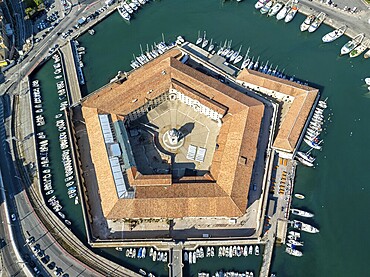 Drone captures of the pentagonal Lazzaretto of Ancona surrounded by harbor waters and boats. This historic Italian quarantine station now serves cultural and civic functions in the city