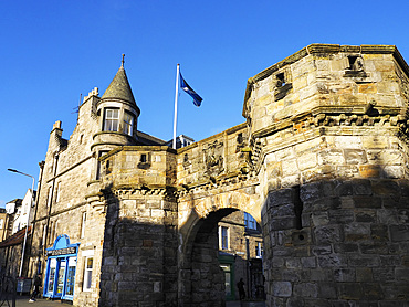 Historic structure at West Port St Andrews showcases local architecture and flags in a clear blue sky in Fife, United Kingdom<br />845-1653 Historic structure at West Port St Andrews showcases local architecture and flags in a clear blue sky in Fife, United Kingdom