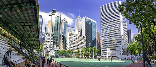 View of Southorn Playground with sports activities and city buildings in Wan Chai District, Hong Kong Island in a sunny day