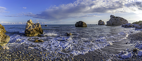 View of Aphrodites Rock and beach with clear sky and small waves at Petra tou Romiou in Cyprus on a sunny day