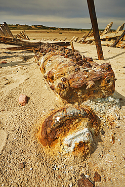 The rusting remains of a boat's engine, in a wreck at Crow Point, on the shore of the Taw and Torridge estuary, near Barnstaple, Devon, Great Britain.