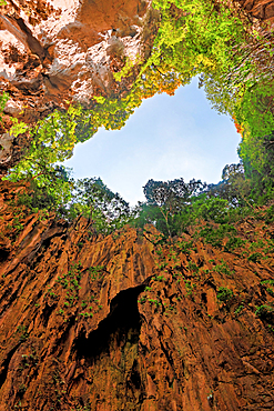 Visitors explore the rock formations and lush greenery of the Batu Caves main cave in Malaysia during daytime<br />1390-1278 Visitors explore the rock formations and lush greenery of the Batu Caves main cave in Malaysia during daytime