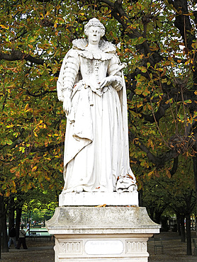 Statue of Marie de Medici stands in the Jardin du Luxembourg surrounded by green trees in Paris