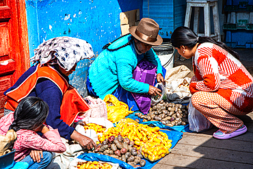 Vegetable vendor selling various types of potatoes in a local village in Peru