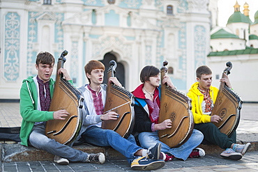 Four young Ukrainian bandurists playing banduras and singing in front of St. Sophia&#39;s Cathedral in Kiev, Ukraine, Europe