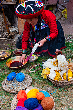 Craftswoman hand dying wool using natural dyes in Peru during traditional textile work